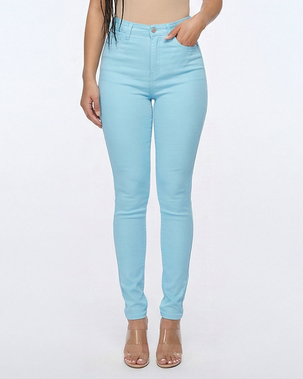 Detail view of light blue skinny jeans worn by model on a white background