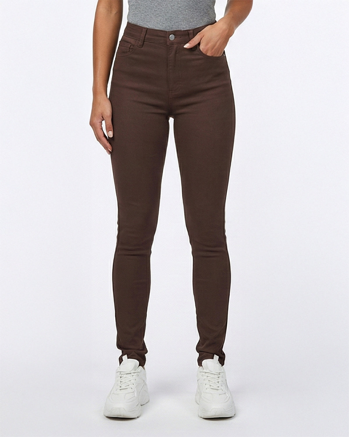Model wearing brown pants and white sneakers on a white background