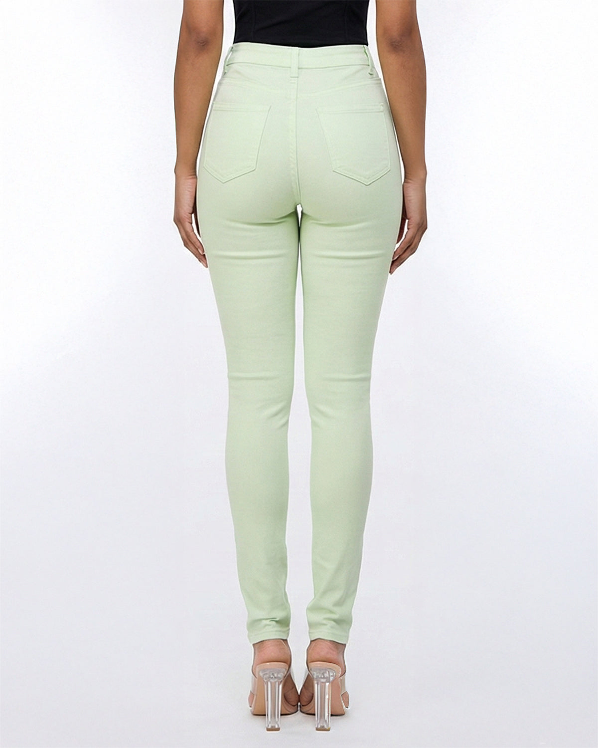 Back view of light green stretch skinny jeans on a model