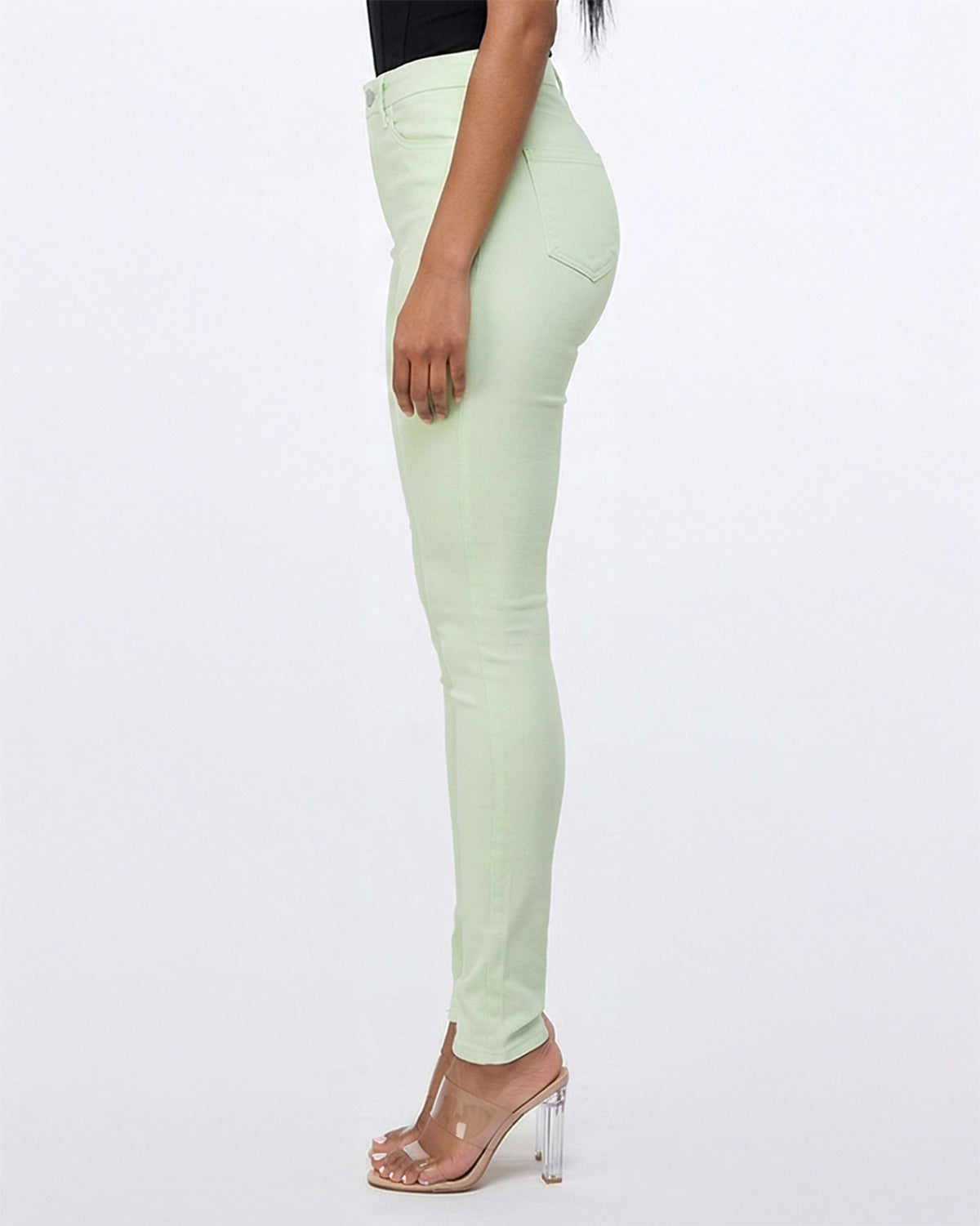 Side view of light green skinny jeans showing the fit on model