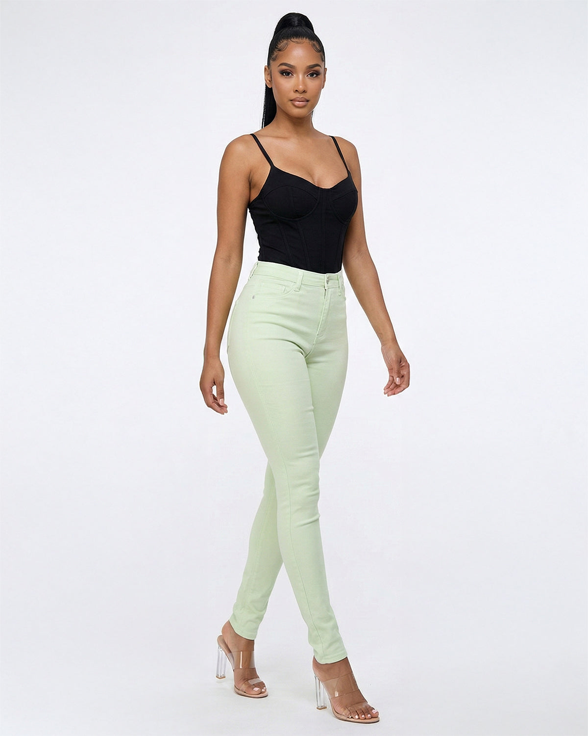 Front view of model wearing light green stretch skinny jeans