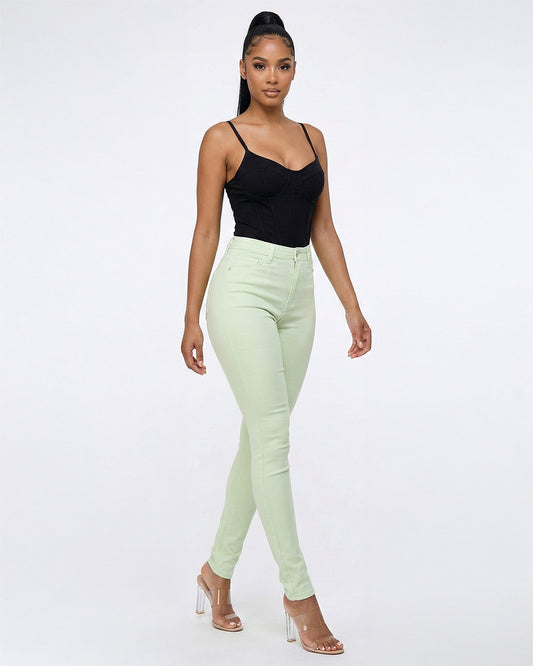 Front view of model wearing light green stretch skinny jeans