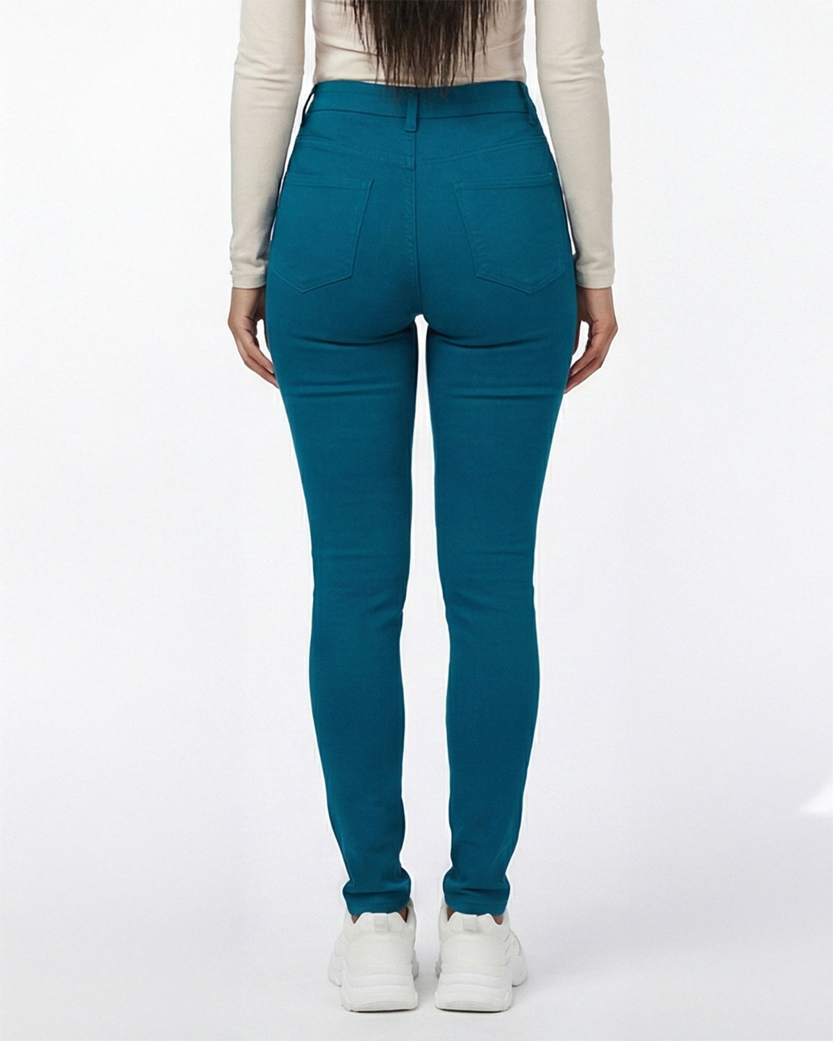 Back view of deep teal stretch skinny jeans on a model