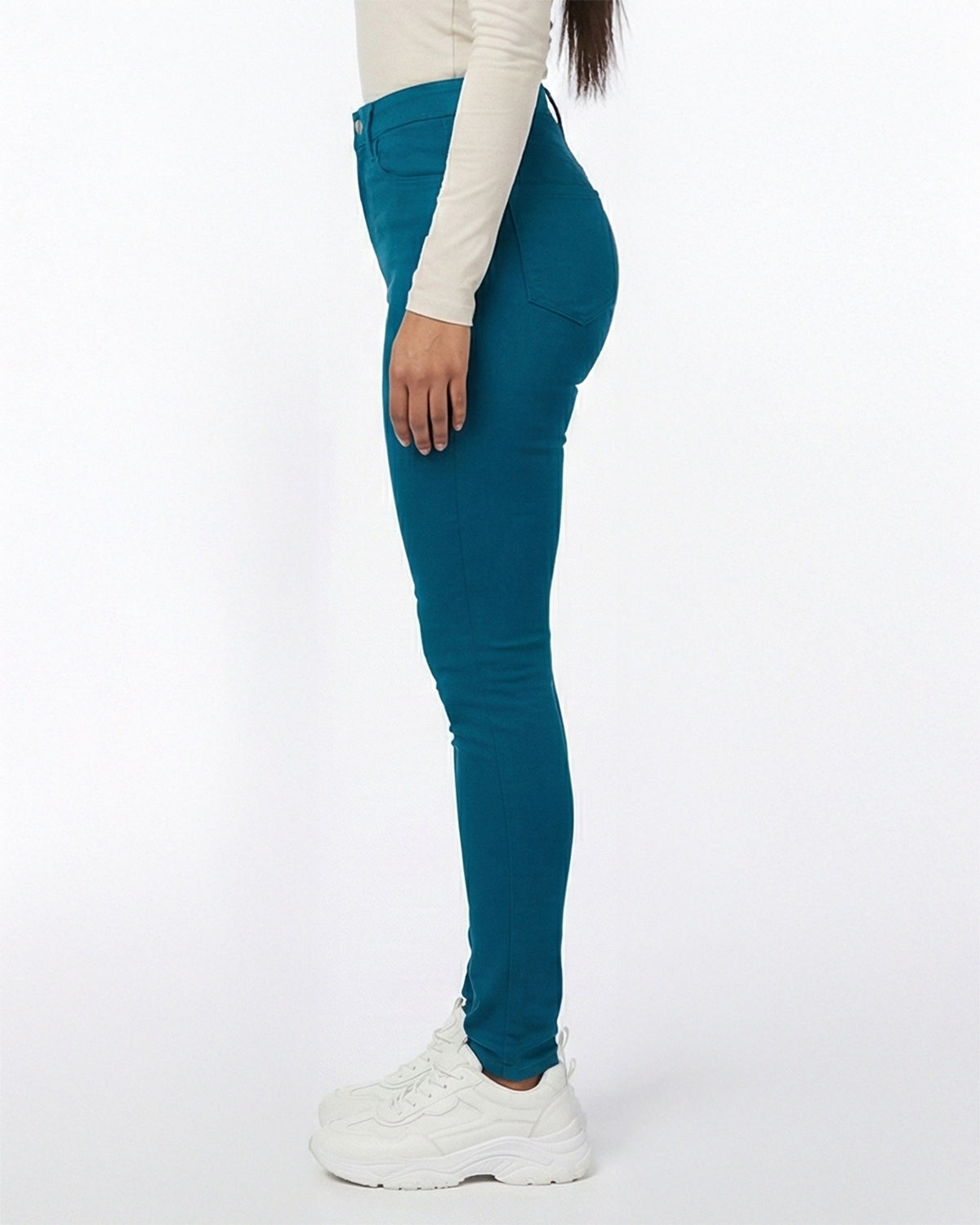 Model wearing deep teal stretch skinny jeans, side angle showing fit