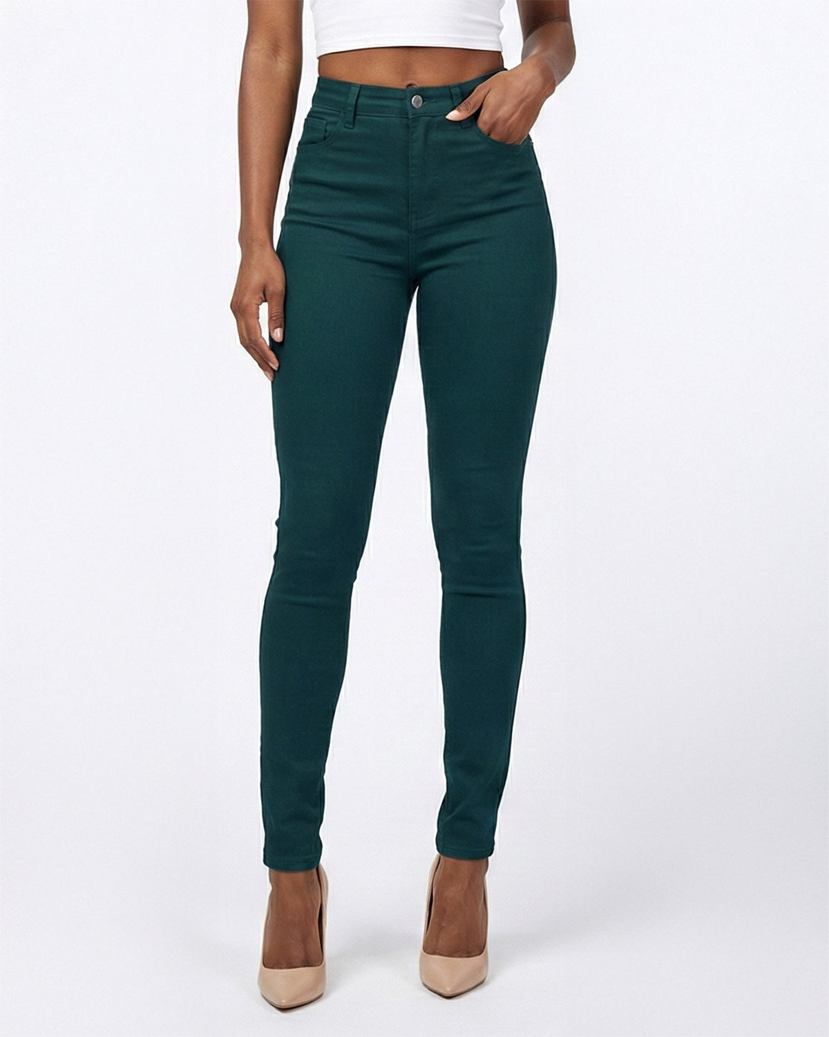 Detail view of dark green skinny jeans worn by model showing front pocket and stitching