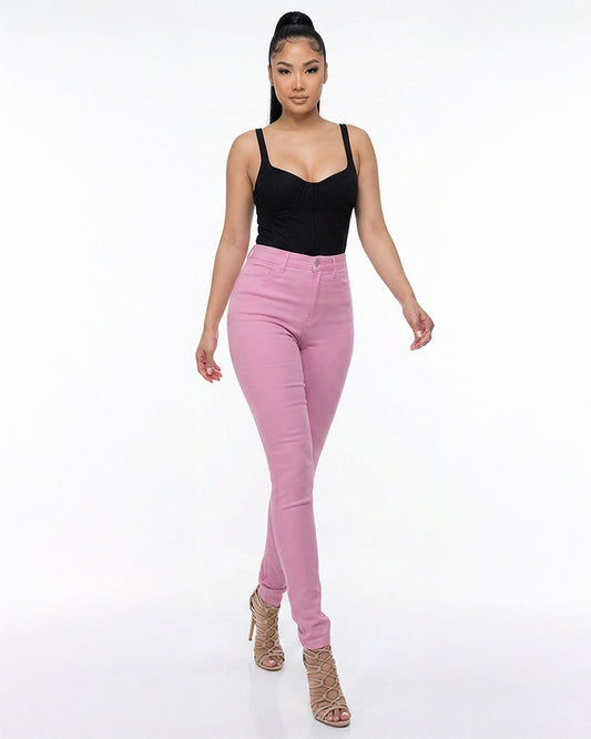 Woman wearing pink skinny jeans and a black top on a white background