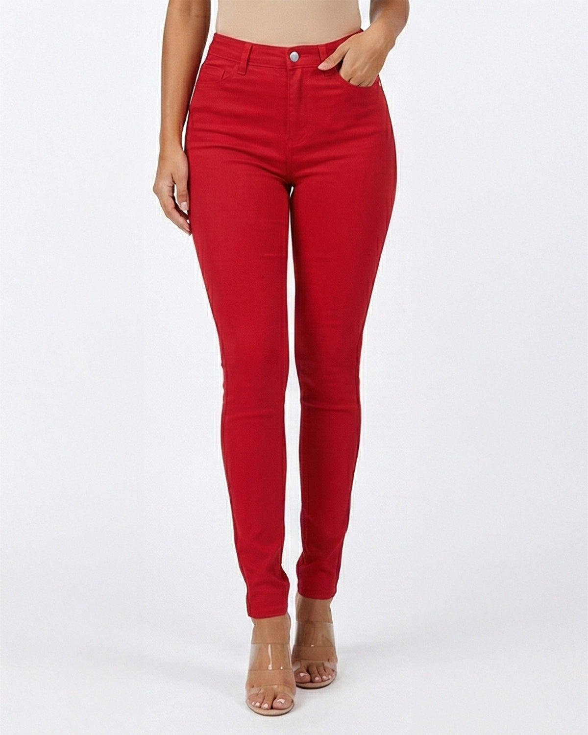 Detail view of red skinny jeans worn by a person on a white background