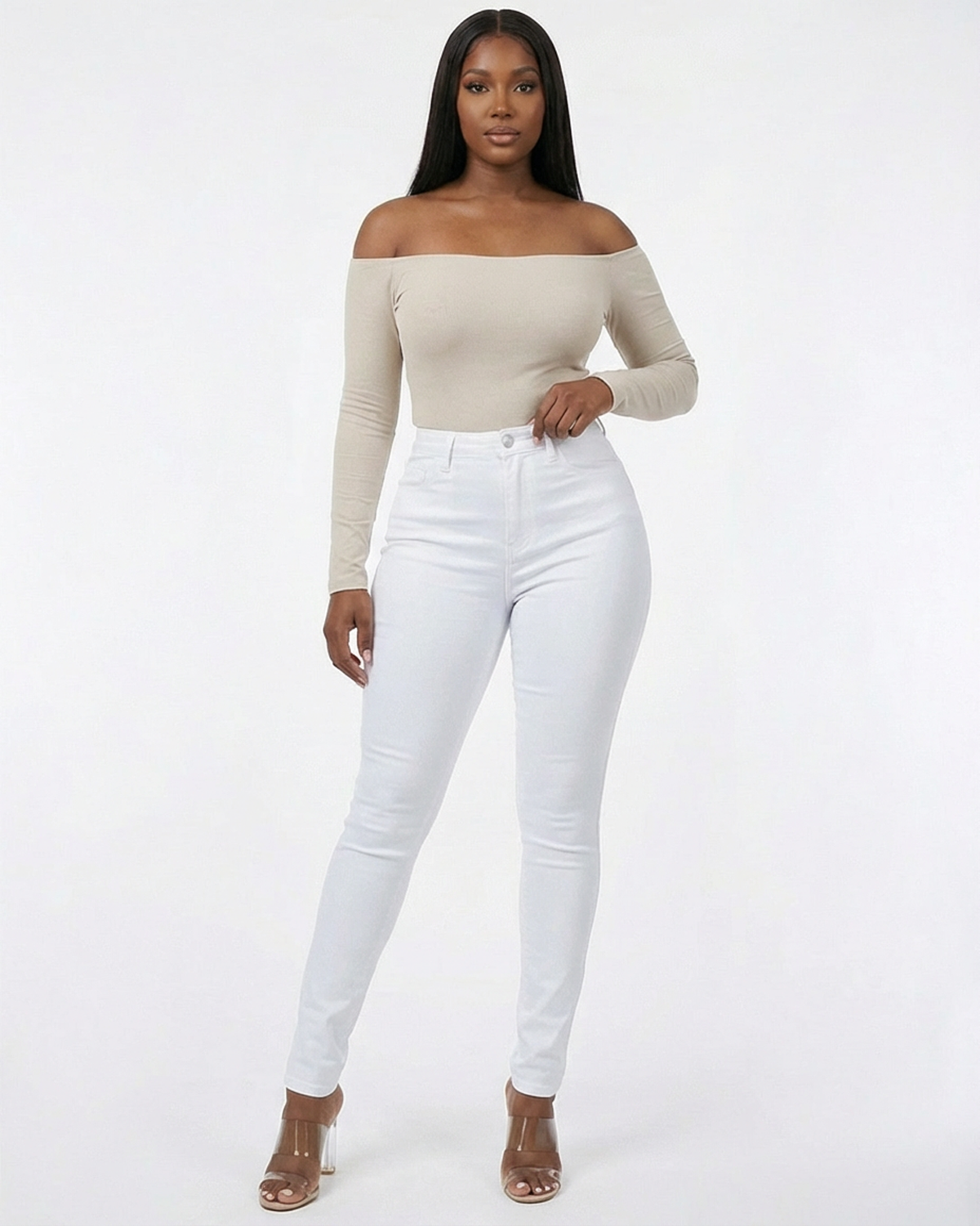 Woman wearing a beige off-shoulder top and a white stretch skinny jeans on a white background