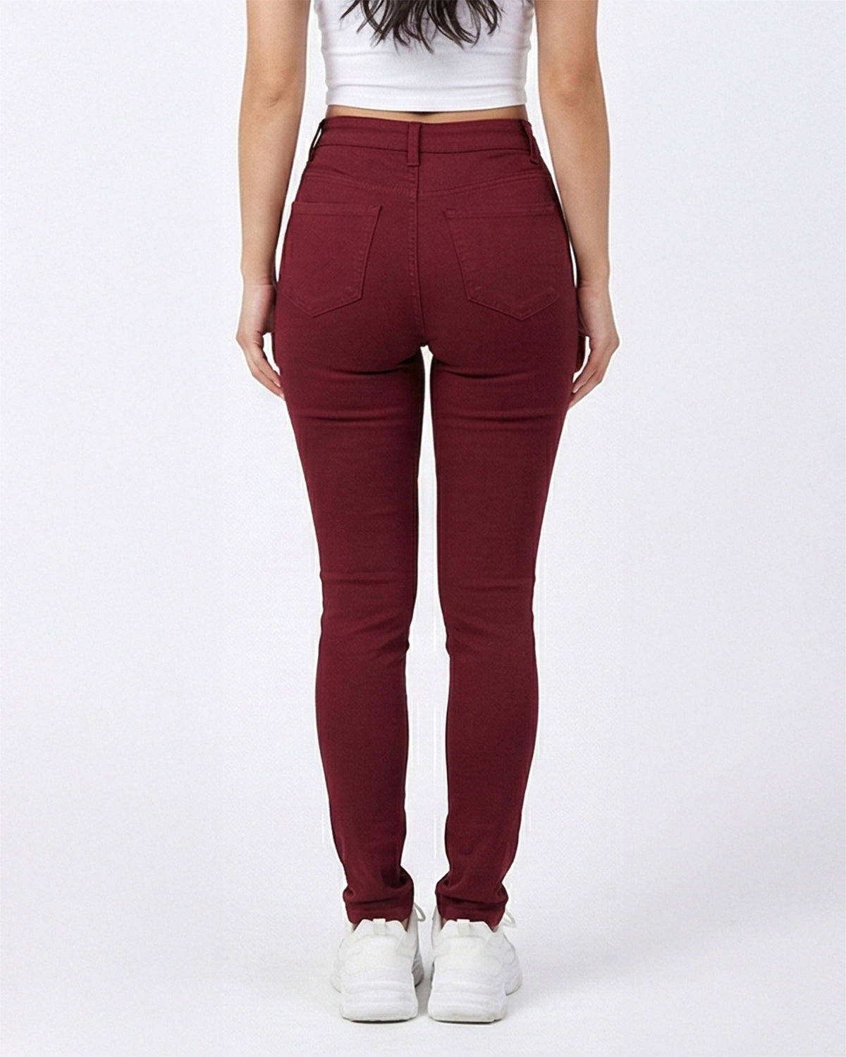 Back view of maroon stretch skinny jeans on a model