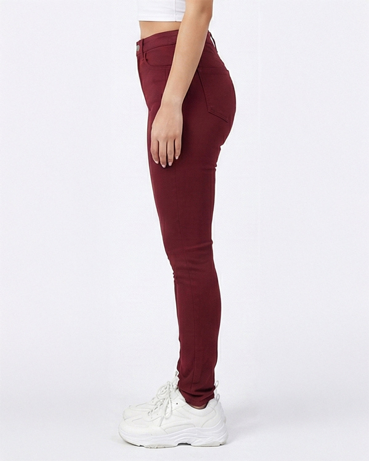 Side angle of maroon skinny jeans showing the fit on model