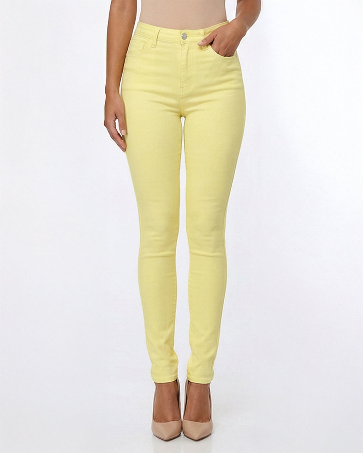 Detail view of yellow skinny jeans worn by model on a white background