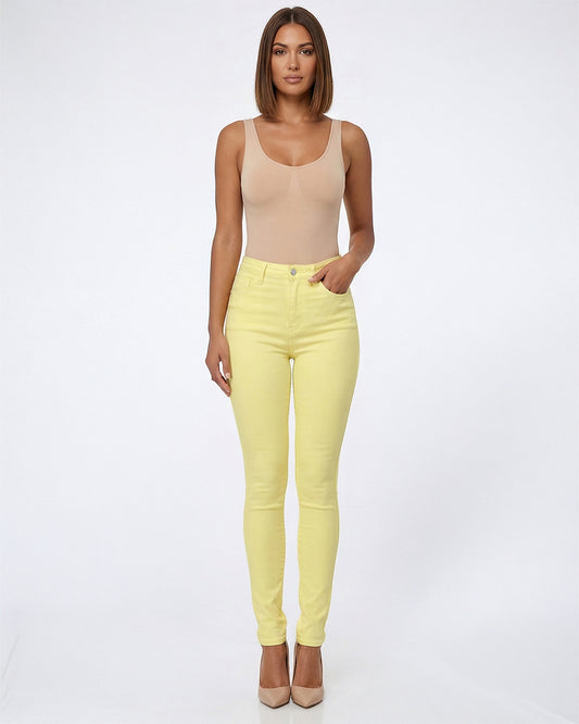 Woman wearing a beige tank top and yellow pants on a white background